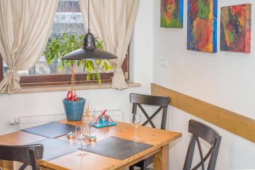 a dining room table with wine glasses and a lamp at Apartments Helena Kranjska Gora in Kranjska Gora