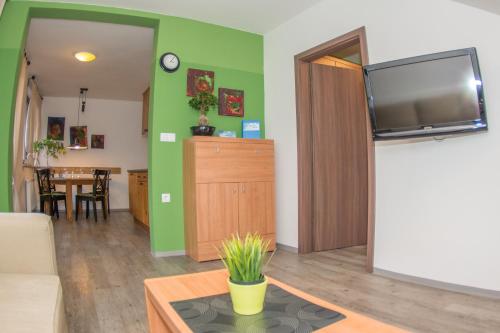 a living room with a flat screen tv and a table at Apartments Helena Kranjska Gora in Kranjska Gora