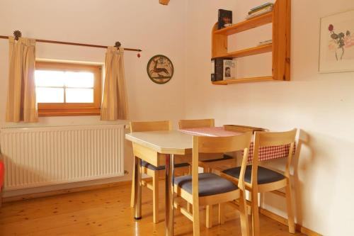 a kitchen with a table and chairs and a window at Ferienwohnung Bacher in Edling