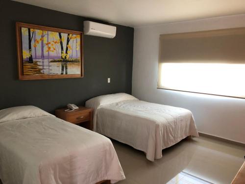 Habitación de hotel con 2 camas y ventana en Casa RyS Hotel en Ocotlán