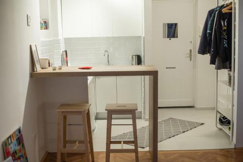 a small kitchen with a counter and two stools at Bright & Stylish Studio Home, superbly located in Sarajevo