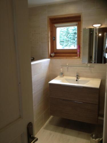 a bathroom with a sink and a tub and a window at Appartement Pied de pistes 6 personnes T4 in Montgenèvre