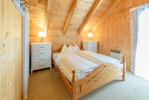 um quarto com uma cama num chalé de madeira em Ferienhaus Kreischberg - Silberhirschen Hütte em Sankt Lorenzen ob Murau