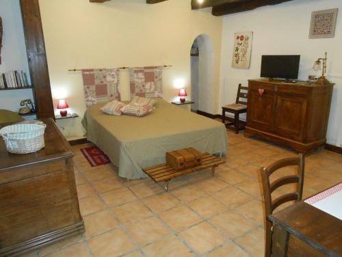 a bedroom with a bed and a dresser and a television at Chambre d'hotes Le Fourniou in Melle