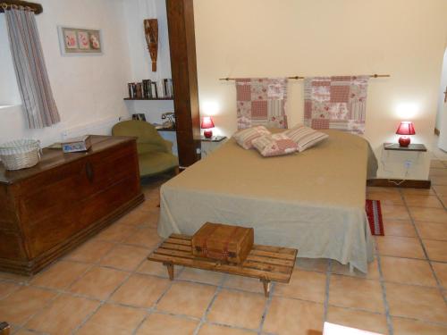 a bedroom with a bed with a briefcase on a bench at Chambre d'hotes Le Fourniou in Melle