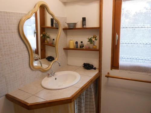 uma casa de banho com um lavatório e um espelho em Chambre d'hotes Le Fourniou em Melle