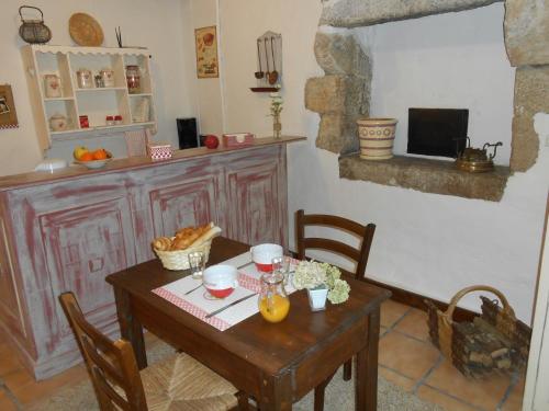 eine Küche mit einem Holztisch sowie einem Tisch und Stühlen in der Unterkunft Chambre d'hotes Le Fourniou in Melle