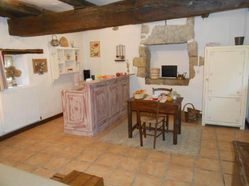 uma cozinha com uma mesa de madeira e uma sala de jantar em Chambre d'hotes Le Fourniou em Melle