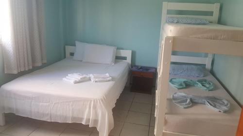 a bedroom with two bunk beds and two pairs of shoes at Pousada Venezia in Fortaleza