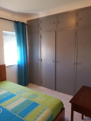 una camera da letto con armadi bianchi, un letto e un tavolo di SUN & SURF ad Aljezur