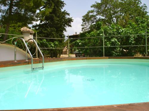 a large blue swimming pool with a metal fence at Agriturismo "Borgo Madonna degli Angeli" - charming cottages in the gardens ! in Tocco da Casauria