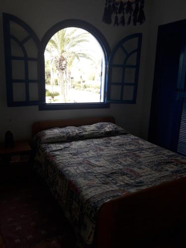 a bedroom with a bed and a window at Villa à Bouznika Bay-plage et golf in Bouznika