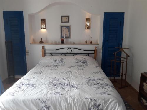 a bedroom with a bed with blue shutters at Villa à Bouznika Bay-plage et golf in Bouznika