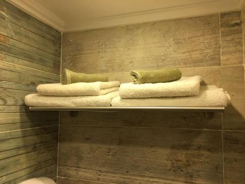 a bathroom with three towels on a shelf at Paris Hotel Cairo in Cairo