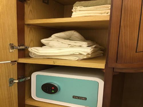 a tv in a cabinet with some towels in it at Paris Hotel Cairo in Cairo
