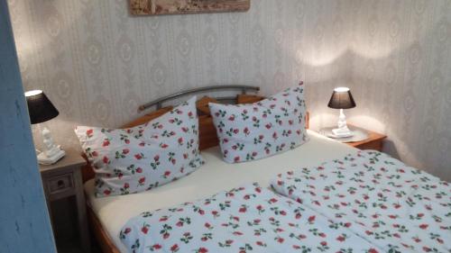 a bedroom with a bed with red and white sheets and pillows at Zum Buddje in Garz-Rügen