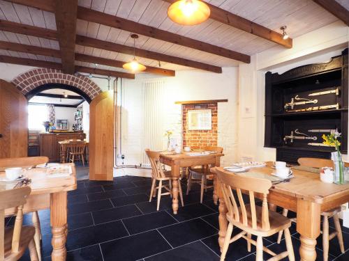 a restaurant with wooden tables and chairs and a fireplace at Rye Windmill B&B in Rye