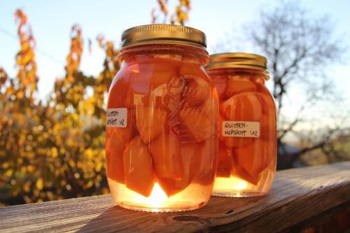 two jars of pickles sitting on a wooden table at Feldererhof in Siusi