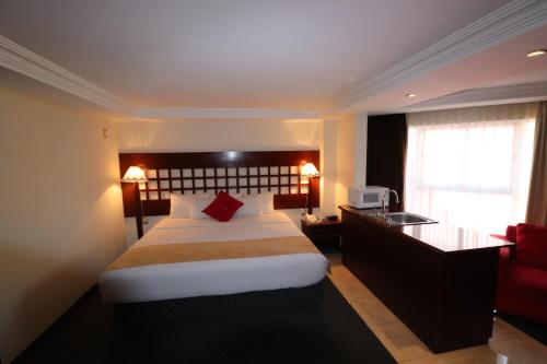 a hotel room with a large bed and a desk at Best Western Toluca in Toluca
