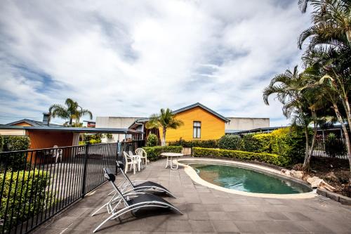 a backyard with a swimming pool and a house at Darra Motel & Conference Centre in Brisbane