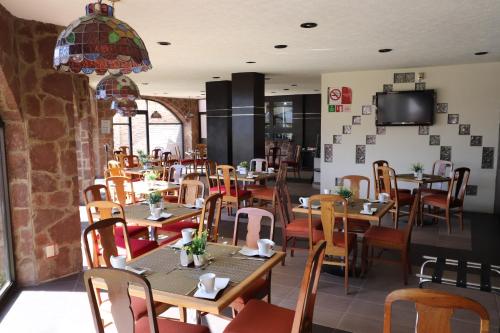 a restaurant with wooden tables and chairs and a tv at Best Western Toluca in Toluca