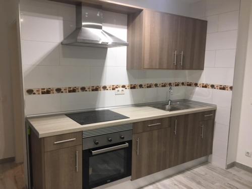 a kitchen with a sink and a stove top oven at Tajinastes in Arona