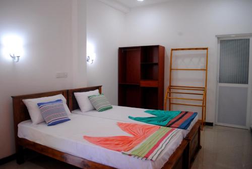 Un dormitorio con una cama con mantas de colores. en Village Villa, en Hikkaduwa