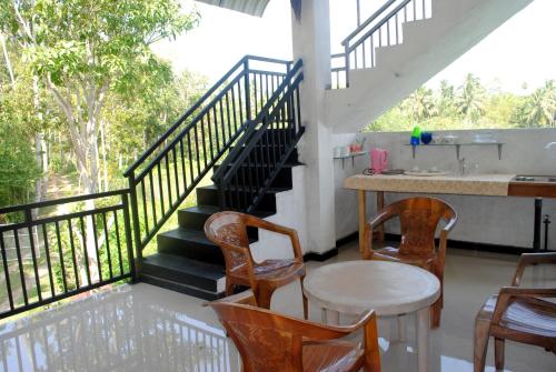 a balcony with a staircase and a table and chairs at Village Villa in Hikkaduwa