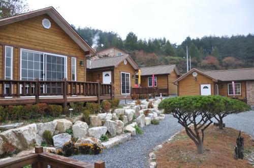 a house with a porch and a yard with rocks at Oraview Pension in Jeongseon