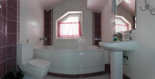 a bathroom with a tub and a sink and a toilet at АртГір гостинний двір in Mykulychyn
