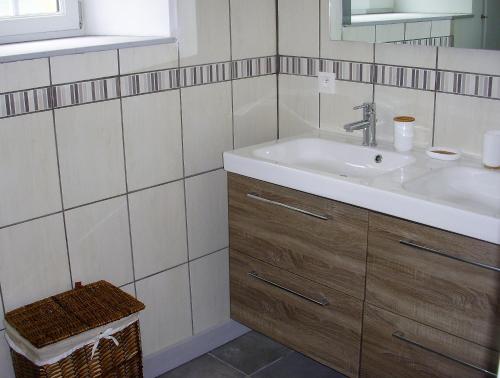 uma casa de banho com um lavatório e um espelho em Les Peupliers em Vesly