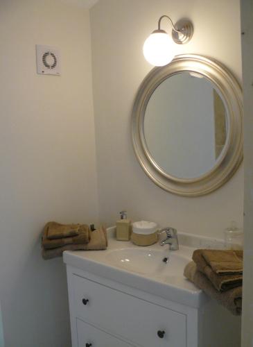 une salle de bain avec un lavabo et un miroir dans l'établissement Mas du Vieux Tilleul, à Vaison-la-Romaine