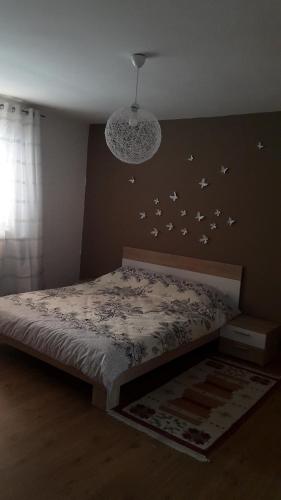 a bedroom with a bed with birds on the wall at Little Paradise in Sarajevo