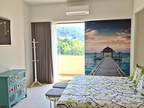 a bedroom with a painting of a pier at By The Sea Suite,Batu Ferringhi in Batu Ferringhi