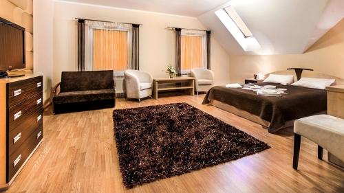 Głogów Małopolski的住宿－翠茲科羅尼酒店，一间卧室配有一张床、一张沙发和一把椅子
