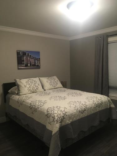 a bedroom with a bed with a white comforter at Quidi Vidi Retreat in St. John's