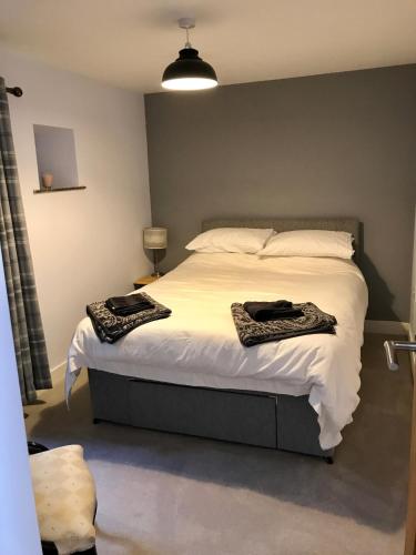 a bedroom with a bed with two towels on it at Red Rose Cottage in Cockermouth