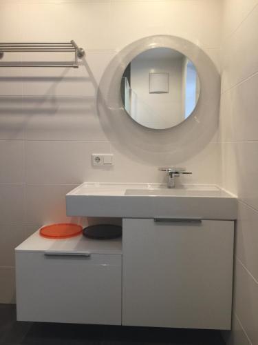 łazienka z białą umywalką i lustrem w obiekcie Ferienwohnung Imbach w Kaprunie