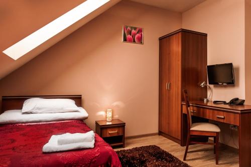 a bedroom with a bed and a desk with a computer at Trzy Korony in Głogów Małopolski