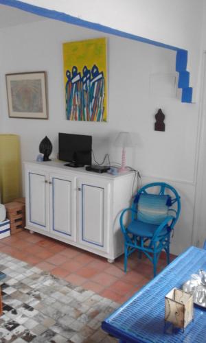 a living room with a tv and a blue chair at Pilar Ruiz in Asilah