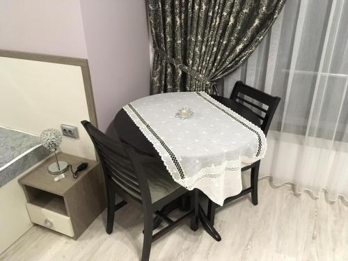 a table and chair with a table and a window at Apartment Park Sveti Vrach in Sandanski
