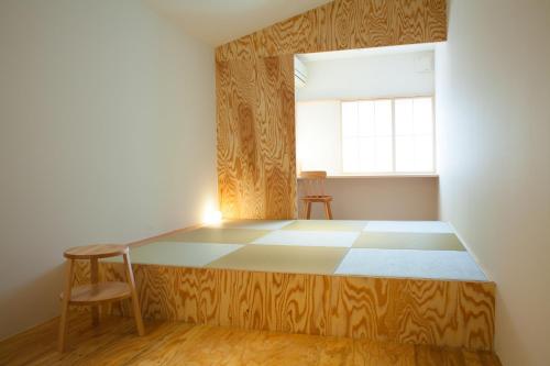 a bed in a room with a chair and a window at Kinsui Annex in Toyooka