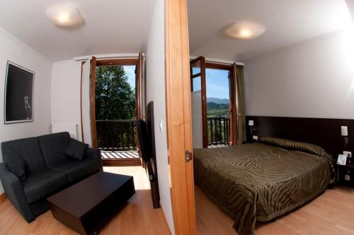 1 dormitorio con 1 cama, 1 silla y 1 ventana en Apartamentos Turisticos Talaimendi, en Zarautz