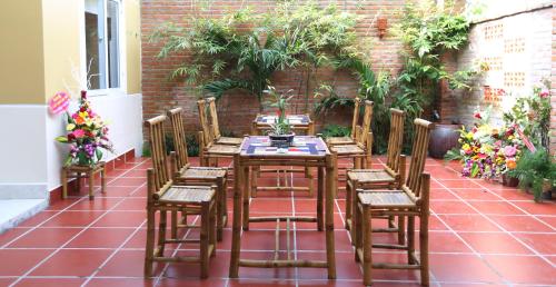 drewniany stół i krzesła na patio z roślinami w obiekcie An Bang Beach Town Homestay w Hoi An