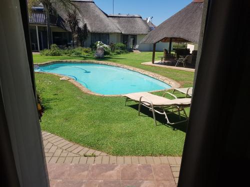 a view of a swimming pool in a yard at 12 On Vaal Drive Guesthouse in Vanderbijlpark