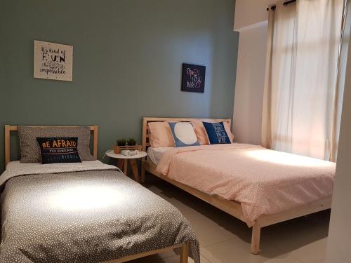 een slaapkamer met twee bedden en een raam bij Nordiska @ Majestic Ipoh in Ipoh