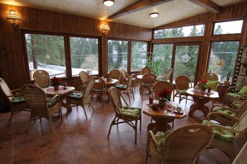 a restaurant with tables and chairs and windows at Chata Javorina in Javorník