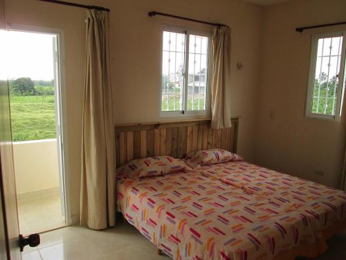 a bedroom with a bed and two windows at Villa Mambo in Patrana