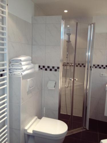 a white bathroom with a shower and a toilet at De Doelen in Leiden