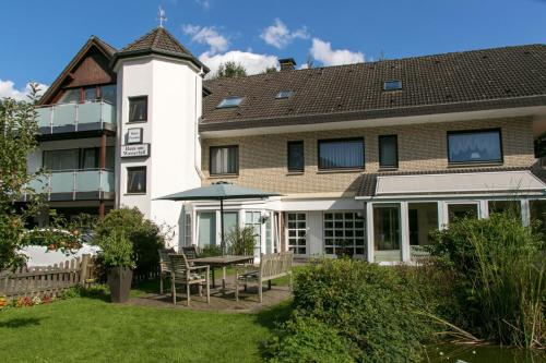a hotel with a table and chairs in a yard at Haus am Wasserfall in Detmold